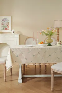 Elegante beige katoenen tafelkleed met fijn bloemenborduurwerk en charmante franjes voor diner.