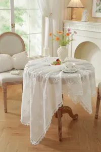 Détail de nappe en dentelle blanche française, tissu en coton brodé pour table à manger.