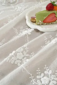 Nappe en dentelle française détail, broderie florale en coton blanc pour décor mariage.