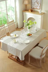 Modern minimalist beige tablecloth with white lace embroidered floral table runner for decor.