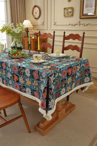 Vista detallada de un mantel jacquard floral vintage con elegantes flecos en el comedor elegante.