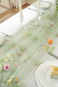 Green lace embroidered table runner with retro colorful floral designs for dining room decor.