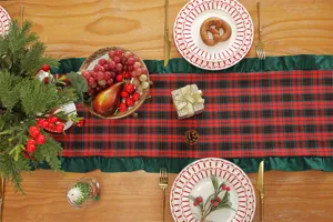Detailed view of Christmas table runner, red green plaid fabric with ruffle edge for decor.