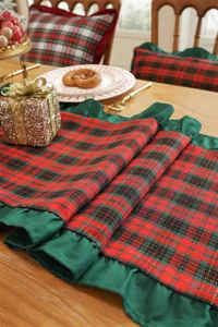 Detailed view of Christmas red and green plaid table runner with delicate ruffled edge decor.
