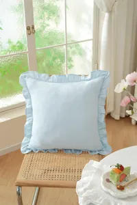 French pastoral light blue ruffled throw pillow cushion detail view, soft cotton material.