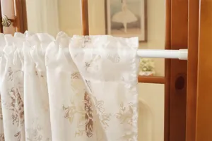 Détail de rideau court en dentelle française, tissu jacquard floral blanc pour cloison de cuisine.
