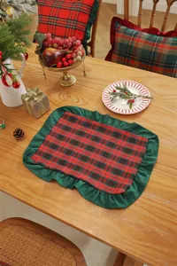 Detail view of the Christmas table mat featuring red and green plaid design with ruffled edges.