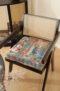 Detailed view of a thick patterned square seat cushion on a retro black wooden chair.