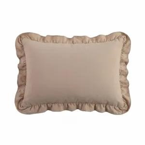 Gros plan détaillé de l'oreiller beige caramel à volants présentant une texture fine.