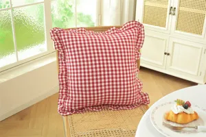 French pastoral red white plaid throw pillow with ruffled edge, cozy home decor detail shot.
