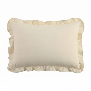 Gros plan d'une housse de coussin beige à volants, mettant en valeur la texture du tissu.