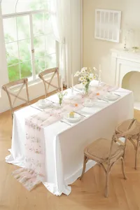Detailed view of a vintage pink floral embroidered lace table runner for wedding and dining.