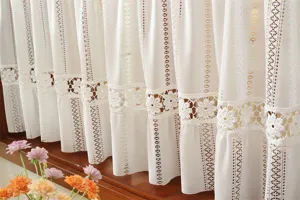 Détail de rideau court en dentelle française, motif floral creux blanc pour cuisine.