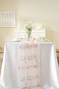 Vintage embroidered pink lace table runner with colorful floral details for wedding and dining decor.