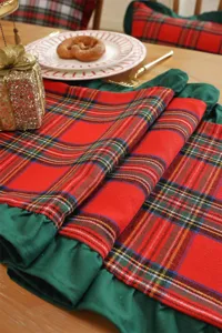 Close-up shot of the festive red and green plaid table runner featuring elegant ruffled edges.