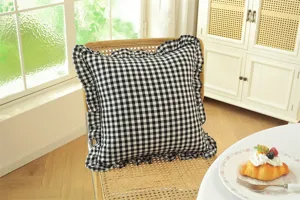 French pastoral black and white plaid throw pillow detail, cozy room setting with soft ruffle trim