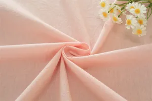 Détail de tissu en coton lavé rose, texture douce pour nappe et décoration d'intérieur.