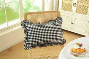 Detailed view of a black and white checkered accent cushion with elegant ruffled edge.