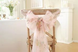 Pink tulle chair sash with delicate flower embroidery, perfect for wedding and party chair decor.