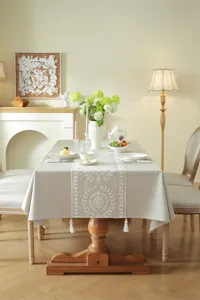 Elegant white lace embroidered table runner with delicate geometric patterns and tassels.