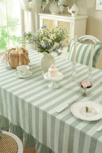 Nappe de table style champêtre français en coton lavé rayé vert avec élégant bord à volants.
