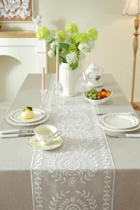 Elegant white lace embroidered table runner detail, modern minimalist home decor accent.