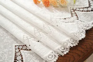 French white embroidered hollow lace detail showing exquisite floral pattern and vintage texture.