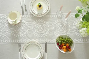 White lace embroidered table runner with floral geometric pattern for dining table decor.