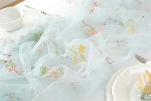 Blue mesh lace table runner with colorful floral embroidery for wedding party decor.