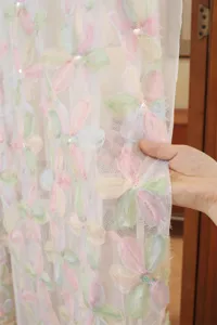 Detailed close-up view of French style pastel embroidered floral mesh fabric curtain material.