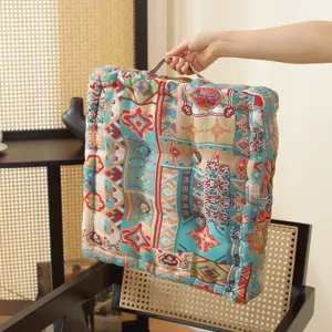 Thick square floor cushion with woven ethnic pattern and handle for home office comfort.