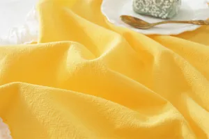Detalle de tela de servilleta de algodón francés, elegante mantel individual amarillo.