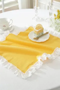 Mantel individual de algodón amarillo estilo francés con encaje, vista de detalle.
