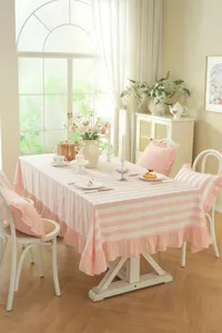 Vue détaillée de la nappe en coton à rayures roses et blanches avec des volants élégants.