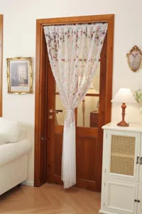 French style floral embroidered sheer door curtain hanging detail in cozy living room.