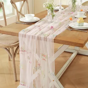 Vintage pink lace table runner with colorful floral embroidery, sheer mesh wedding dining decor.