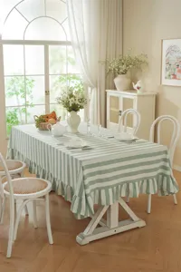 Détail nappe style campagnard français rayé vert, coton lavé avec bord volanté délicat.