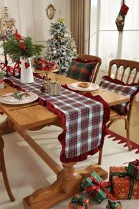 Christmas table runner with red green plaid and ruffled edges for holiday home decor.