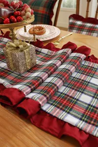 Detail view of Christmas plaid table runner with red ruffles for holiday dining decor.
