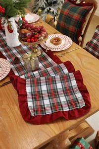 Detailed view of the Christmas table runner featuring red and green plaid with elegant ruffles.