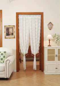 Scene detail of the elegant French lace door curtain with hanging beads, soft interior decor.