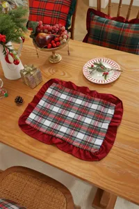 Christmas plaid placemat with red ruffle edge, festive cotton-polyester table decor.