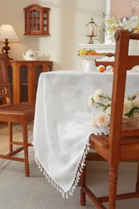 Weisse Polyester Tischdecke mit elegantem Gittermuster und Fransen für Esstisch oder Couchtisch.
