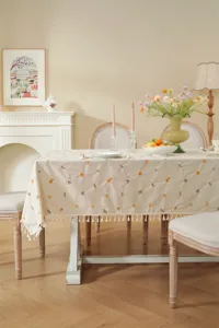 Gedetailleerd prachtig geborduurd tafelkleed met delicate bloemmotieven en franjes.