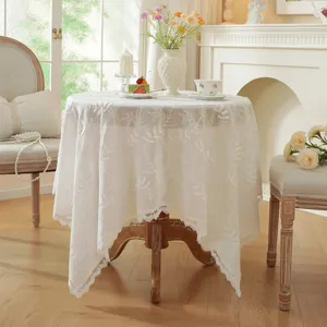 Belle nappe de table ronde en coton blanc style français avec broderie florale élégante.