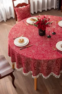 Nappe ronde en jacquard rouge avec motif floral doré élégant et bordure en dentelle de gland blanc.