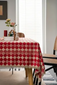 Red diamond check tablecloth with delicate gold lace edge, perfect for dining table decor in detail.