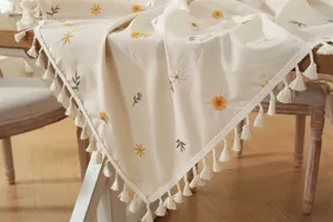Gedetailleerd overzicht van een katoenen tafelkleed met geborduurde bloemmotieven.
