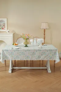 Dettaglio tovaglia in cotone jacquard francese, elegante motivo floreale con frange a pompon.