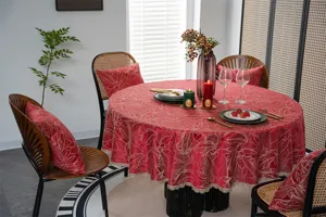 Detailed view of the festive red jacquard round tablecloth with gold lace edges and matching pillows.